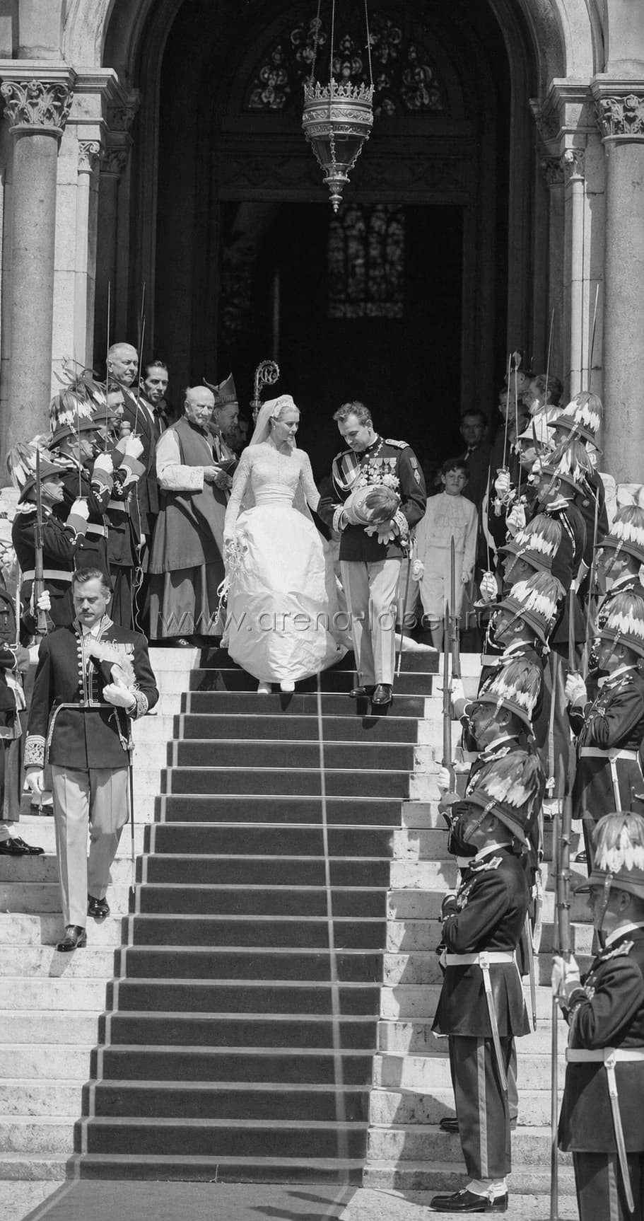 Грейс Келли и князь Ренье III после церемонии: невеста в кружевном платье с длинными рукавами и пышной юбкой