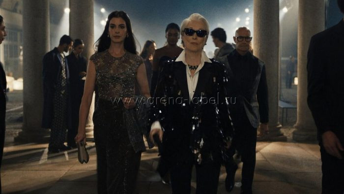 Героини фильма «Дьявол носит Prada 2» идут по вечернему залу на модном мероприятии: строгие чёрные образы, блеск пайеток, винтажные детали и атмосфера современной индустрии моды после эпохи глянца